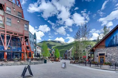 a street in a town with buildings and mountains at River Run Village Condos - 2 Bedroom - Walk To Lift! in Keystone