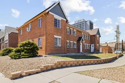 a red brick house with a driveway at Modern Comfort - King Beds - Walk to Sloans Lake in Denver
