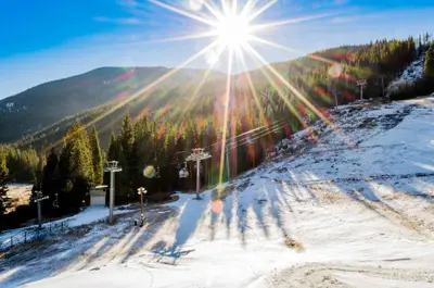 a sun shining on a snow covered ski slope at 8045 Black Bear condo in Keystone