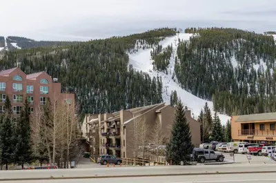 a resort with a snow covered mountain in the background at 8045 Black Bear condo in Keystone