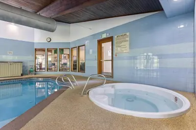 a large tub in a room next to a swimming pool at Cozy Winter Park Condo Bike, Ski, and Hike! in Winter Park