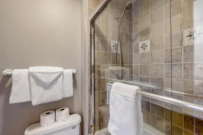 a bathroom with a shower and a toilet and towels at 2 Bedroom Montezuma Condo At Lakeside Village - Shuttle To Slopes! in Keystone