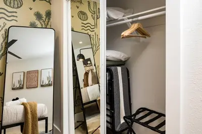 a dressing room with a mirror and a bed at Wild West Disco Haus 2! New Hot Tub, Patio + Gym in Denver