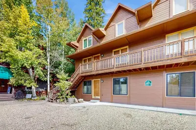 a house with a balcony on the side of it at On the Rapids - A Unit in Grand Lake