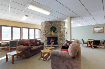 a living room with couches and a stone fireplace at Silver Lodge B in Granby