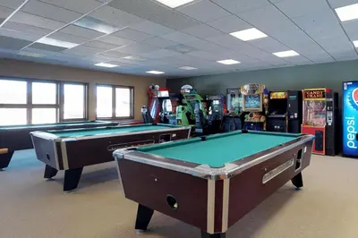 two pool tables in a room with arcade machines at Silver Lodge A & B in Granby