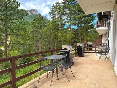 a patio with tables and chairs on a balcony at Fawn Valley Inn- 105 condo in Estes Park