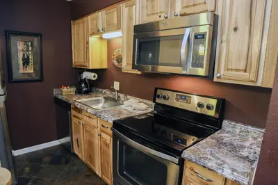 a kitchen with a stove and a microwave and a sink at Fawn Valley Inn- 286 condo in Estes Park
