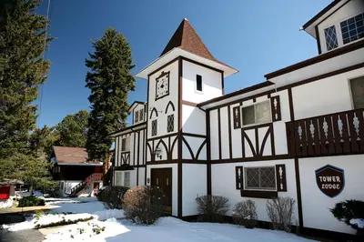 a building with a clock tower in the snow at Fawn Valley Inn- 254 apts in Estes Park