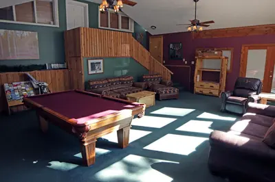 a living room with a pool table and a staircase at Timber Creek Chalets- 3 chalet in Estes Park