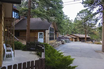 a house with a fence next to a driveway at Timber Creek Chalets- 11 chalet in Estes Park