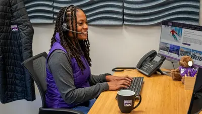 a woman sitting at a desk with a headset at Alpenglow Peaks Lodge in Breckenridge