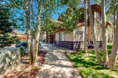 a house with trees in front of a sidewalk at Blue River Grove in Silverthorne
