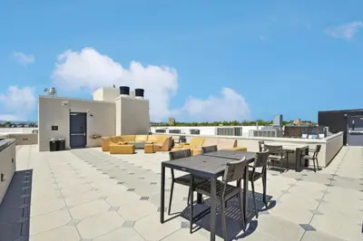 a patio with a table and chairs on a roof at Canvas & Comfort | Espadin LoHi in Denver