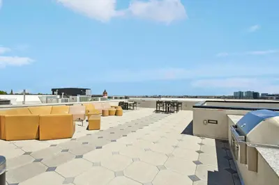 a patio with yellow chairs and tables on a roof at Skytop Perspective | Espadin LoHi in Denver