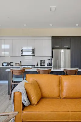 a living room with a brown couch in a kitchen at Lofted Living | Espadin LoHi in Denver