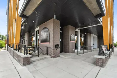 a brick building with a black roof at Rosé All Day | Espadin LoHi in Denver