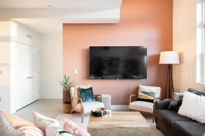 a living room with a couch and a tv on a wall at Bold & Elevated | Espadin LoHi in Denver