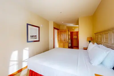 a bedroom with a large white bed with white pillows at Mountainside Majesty in Keystone