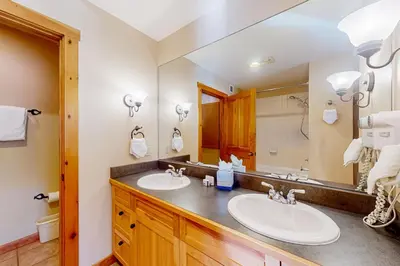 a bathroom with two sinks and a large mirror at Mountainside Majesty in Keystone