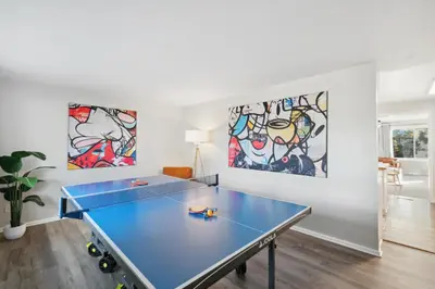 a blue ping pong table in a room with paintings at NEW • Modern • 4BR • Game Rm • Ping-Pong in Arvada