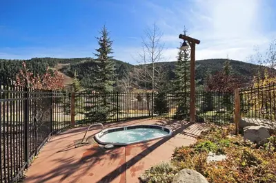 a hot tub on a patio with a fence at 2656 Tenderfoot Lodge condo in Keystone
