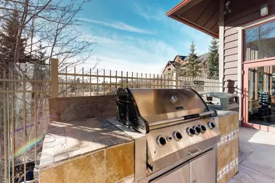a grill on a patio outside of a house at Red Hawk Lodge 2 Bedroom Condo In River Run Village in Keystone