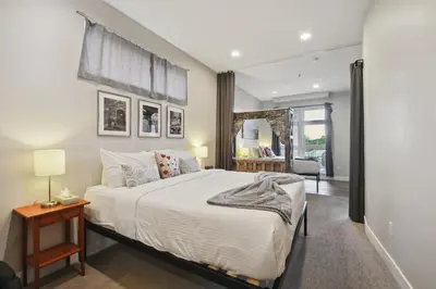 a bedroom with a large bed and a mirror at Graffiti & Skyline | RiNo Art Lofts in Denver