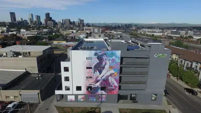 a building with a large painting on the side of it at Cowboy Muse | RiNo Art Lofts in Denver