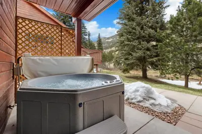 a hot tub on the patio of a house at Bugle Pointe A13 by Estes Park Condos in Estes Park