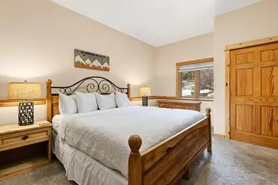 a bedroom with a large bed and a window at Bugle Pointe A13 by Estes Park Condos in Estes Park