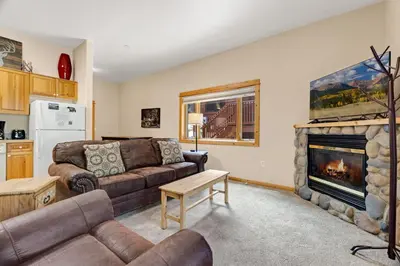 a living room with a couch and a fireplace at Bugle Pointe A13 by Estes Park Condos in Estes Park