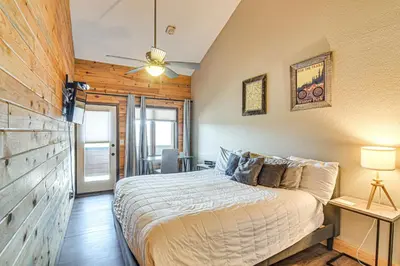 a bedroom with a bed and a wooden wall at Hot Tub and Indoor Pool Access at Granby Condo in Granby