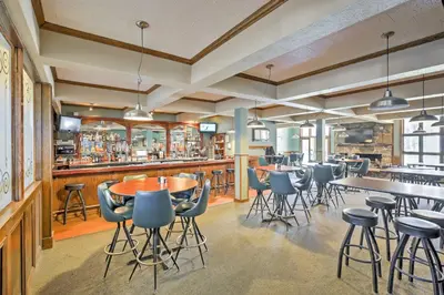 a restaurant with tables and chairs and a bar at Hot Tub and Indoor Pool Access at Granby Condo in Granby