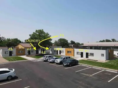 a parking lot with cars parked in front of a building at Chic & intimate 2 bedroom in Brighton