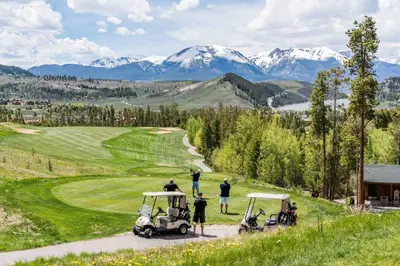 a group of people playing golf on a golf course at Beautiful 2BR in River Run - Kids Ski Free! condo in Dillon