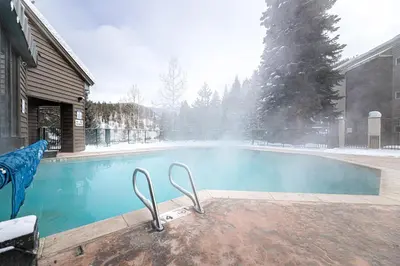 a swimming pool in a yard with snow on it at Iron Horse C4093 condo in Winter Park