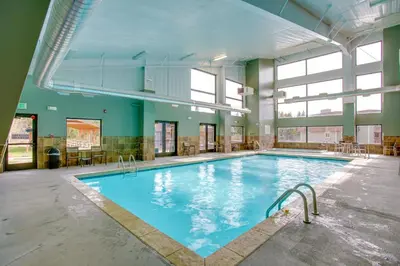 a large indoor swimming pool with blue water at Riverside Condo in Downtown Winter Park! in Winter Park