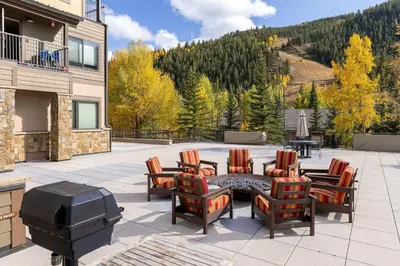 a patio with a grill and chairs and a table at 2782 Slopeside condo in Keystone