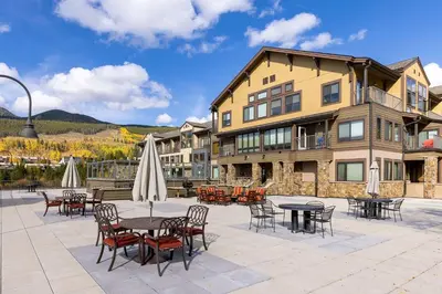 a patio with tables and chairs in front of a building at 2782 Slopeside condo in Keystone