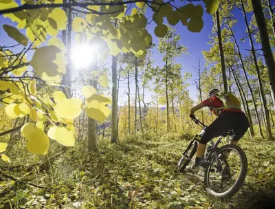 a person riding a bike on a trail in the woods at The Rail Haven townhouse in Winter Park