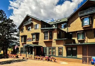 a large wooden building with flowers in front of it at Diamond - The Historic Crags Lodge - ST in Estes Park