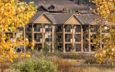 a large apartment building with a mountain in the background at Worldmark Granby Rocky Mountain 1BD in Granby