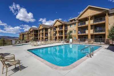 a swimming pool at a resort with chairs and a building at Worldmark Granby Rocky Mountain 2BD in Granby