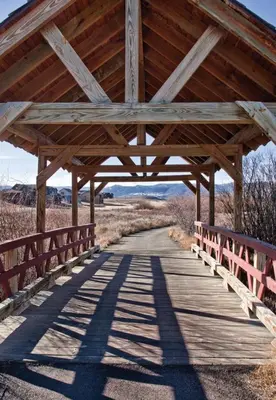a wooden bridge with a wooden roof over a road at Worldmark Granby Rocky Mountain 2BD in Granby