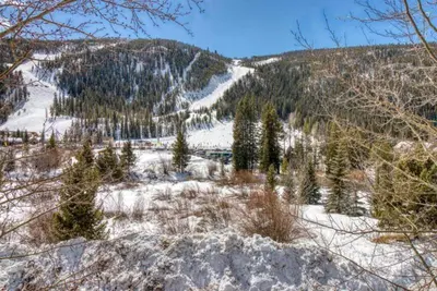 a snow covered hill with trees and a mountain at Tenderfoot Lodge 2 Bedroom At The Mountain House Base in Keystone