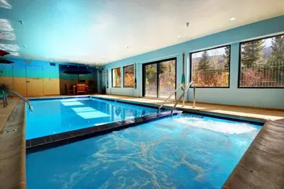 a large swimming pool with blue water in a house at 2 Bedroom Gateway Lodge Condo Near Mountain House in Keystone