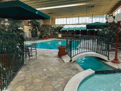 a swimming pool with a bridge in a building at Quality Inn & Suites Fort Collins East in Fort Collins