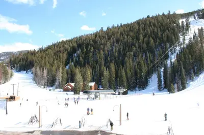 a group of people skiing down a snow covered mountain at Ski Run 303 by SummitCove Lodging in Keystone