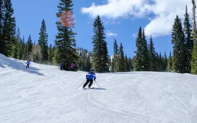 a group of people skiing down a snow covered slope at Ironwood 2996 by SummitCove Lodging in Keystone
